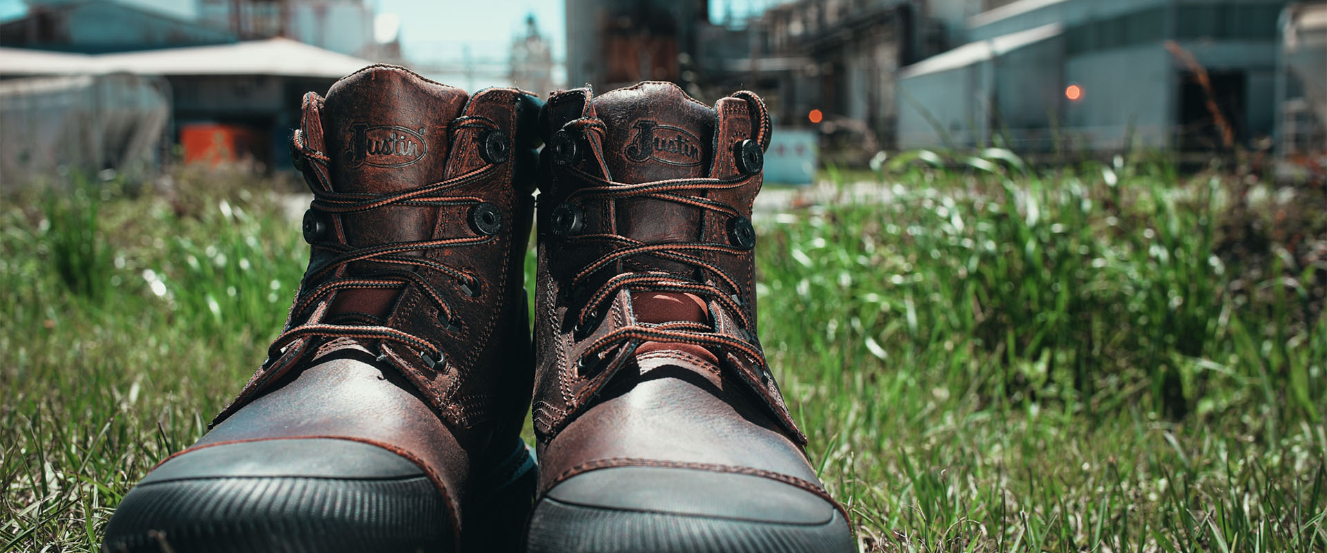 Pair of Justin Warhawk nano comp toe lace up boots in brown